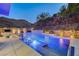 Luxury pool and spa with waterfall feature at night at 5 Highland Cove Ln, Henderson, NV 89011