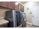 Laundry room with LG washer and dryer, dark brown cabinets, and tile floor at 528 Copper View St, Henderson, NV 89052