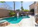 Relaxing pool with a rock waterfall and slide, surrounded by lush landscaping at 528 Copper View St, Henderson, NV 89052