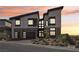 Modern two-story home with a three-car garage, desert landscaping, and sleek architectural design at dusk at 5436 Succulent Rose Dr, Las Vegas, NV 89135