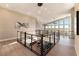 Bright hallway with modern railings and a view of the living space below with high windows at 5436 Succulent Rose Dr, Las Vegas, NV 89135