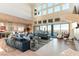 Bright living room with sectional sofa, floor-to-ceiling windows, and sliding glass doors to the backyard at 5436 Succulent Rose Dr, Las Vegas, NV 89135