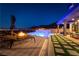 Night view of a modern pool and spa with a fire feature and lounge area with city views at 5436 Succulent Rose Dr, Las Vegas, NV 89135