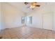 Bright and airy living room featuring neutral tile flooring, a ceiling fan, and multiple windows at 551 Morning Mauve Ave, Las Vegas, NV 89183