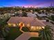 Aerial shot of a home featuring a well-manicured lawn, mature palms, and a tile roof at 5555 W Desert Inn Rd, Las Vegas, NV 89146