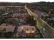 Dusk aerial view showcasing the house with manicured landscape, and a sprawling cityscape at 5555 W Desert Inn Rd, Las Vegas, NV 89146