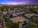 Aerial view of a desert home with lush front lawn, a circle driveway, and city views at 5555 W Desert Inn Rd, Las Vegas, NV 89146