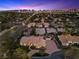 An elevated view showcasing the property's layout, tile roof, circular driveway, and proximity to the city skyline at 5555 W Desert Inn Rd, Las Vegas, NV 89146