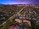 An aerial view showcasing the property and the sprawling city at dusk at 5555 W Desert Inn Rd, Las Vegas, NV 89146