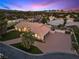 An aerial view featuring the house with lush front lawn, mature palms, and wide driveway at 5555 W Desert Inn Rd, Las Vegas, NV 89146