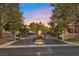 Gated entrance to a private community framed by mature trees, block walls, and lush landscaping at 5555 W Desert Inn Rd, Las Vegas, NV 89146