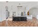 Spacious kitchen featuring custom dark cabinets, large island, and decorative lighting fixture at 5555 W Desert Inn Rd, Las Vegas, NV 89146