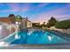 Inviting pool featuring waterfall and outdoor seating area at twilight at 5555 W Desert Inn Rd, Las Vegas, NV 89146