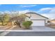 Single-story house with a white garage door and desert landscaping at 5725 Copper Sun Ct, North Las Vegas, NV 89031