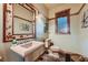 Charming bathroom with a pink pedestal sink, decorative mirror, and wood accents at 5895 S Gateway Rd, Las Vegas, NV 89120