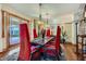 Elegant dining room with red velvet chairs, hardwood floors, and access to the backyard at 5895 S Gateway Rd, Las Vegas, NV 89120