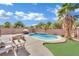 Pool and patio area with fire pit, and lush landscaping at 6145 Sydney Bay Ct, North Las Vegas, NV 89081