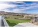 Expansive backyard showcasing a manicured lawn and panoramic golf course and mountain vistas at 631 Cityview Ridge Dr, Henderson, NV 89012