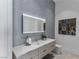 Stylish bathroom with a textured wall, illuminated mirror, double vanity, and modern fixtures at 631 Cityview Ridge Dr, Henderson, NV 89012