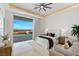 Bright bedroom features a ceiling fan and sliding glass doors that opens to a balcony with seating area at 631 Cityview Ridge Dr, Henderson, NV 89012