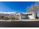 Modern home featuring a minimalist design, clear garage doors and desert landscaping at 631 Cityview Ridge Dr, Henderson, NV 89012