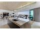 Modern kitchen island with stone countertop and sink overlooking the outdoor dining area and mountain views at 631 Cityview Ridge Dr, Henderson, NV 89012