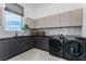 Well-organized laundry room with modern cabinetry, sleek countertops, and high-end washer and dryer at 631 Cityview Ridge Dr, Henderson, NV 89012