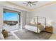 Bright main bedroom features a gold four poster bed and sliding glass doors to an outdoor seating area with city views at 631 Cityview Ridge Dr, Henderson, NV 89012