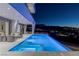 Modern pool with a spa and views of the surrounding mountains and city lights at dusk at 631 Cityview Ridge Dr, Henderson, NV 89012