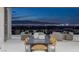 Elegant outdoor dining and lounge area with spectacular city views at twilight at 631 Cityview Ridge Dr, Henderson, NV 89012