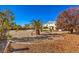 Landscaped backyard with palm trees and gravel. Two-story house visible in background at 6971 Cedar Basin Ave, Las Vegas, NV 89142