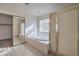 Bathroom with a large bathtub, tiled flooring, and double mirrored closet doors at 6971 Cedar Basin Ave, Las Vegas, NV 89142