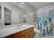 Clean bathroom featuring a shower-tub combo, wood vanity, large mirror, and tile flooring at 705 Thousand Oaks Dr, Las Vegas, NV 89123