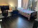 Bedroom with twin bed, dark flooring, and home office setup at 705 Thousand Oaks Dr, Las Vegas, NV 89123