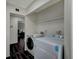 Convenient laundry area featuring a washer, dryer, and ample shelving for storage solutions at 705 Thousand Oaks Dr, Las Vegas, NV 89123