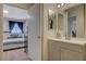 En-suite bathroom featuring a modern vanity and a partial view into the well-lit bedroom at 7885 W Flamingo Rd # 1037, Las Vegas, NV 89147