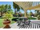 Outdoor seating area featuring a table with benches, shaded by a pergola in a well-maintained community space at 7885 W Flamingo Rd # 1037, Las Vegas, NV 89147