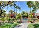 Gated community pool area featuring lush landscaping, shade structures, and a paved walkway at 7885 W Flamingo Rd # 1037, Las Vegas, NV 89147