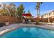 Inviting pool area with patio furniture under red umbrellas at 8501 Vivid Violet Ave, Las Vegas, NV 89143