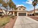 Two-story house with brown garage door and landscaped yard at 9570 Lavarun Ct, Las Vegas, NV 89123