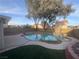 Backyard pool and spa with rock features, mature trees, and privacy fence at 9570 Lavarun Ct, Las Vegas, NV 89123