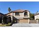 Tan two-story house with tile roof, landscaping, and a two-car garage at 9843 Frosty Canyon Ct, Las Vegas, NV 89183