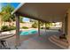 This is a covered patio that overlooks a backyard with a custom pool and mature landscaping at 9843 Frosty Canyon Ct, Las Vegas, NV 89183