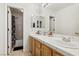 Bright bathroom featuring a double vanity, large mirror and shower/tub combo at 9916 Sierra Canyon Way, Las Vegas, NV 89147