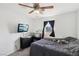 Cozy bedroom with large window, mounted television, dark curtains, ceiling fan and overhead lighting at 9916 Sierra Canyon Way, Las Vegas, NV 89147