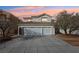 Two-story home featuring a three-car garage, mature trees, and ample driveway space on a well-maintained lot at 9916 Sierra Canyon Way, Las Vegas, NV 89147