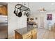 Kitchen island with granite top, hanging pot rack and stainless steel fridge in view at 9916 Sierra Canyon Way, Las Vegas, NV 89147