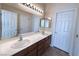 Bathroom with a large mirror, double sinks, storage cabinets, and tile flooring at 8682 Waterford Bend St, Las Vegas, NV 89123