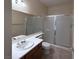 Bathroom featuring a single sink vanity, a walk-in shower with glass doors, and tile flooring at 8682 Waterford Bend St, Las Vegas, NV 89123