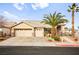 Single-story house with two-car garage, landscaping, and palm trees at 1036 Aspen Daisy Ave, Henderson, NV 89074